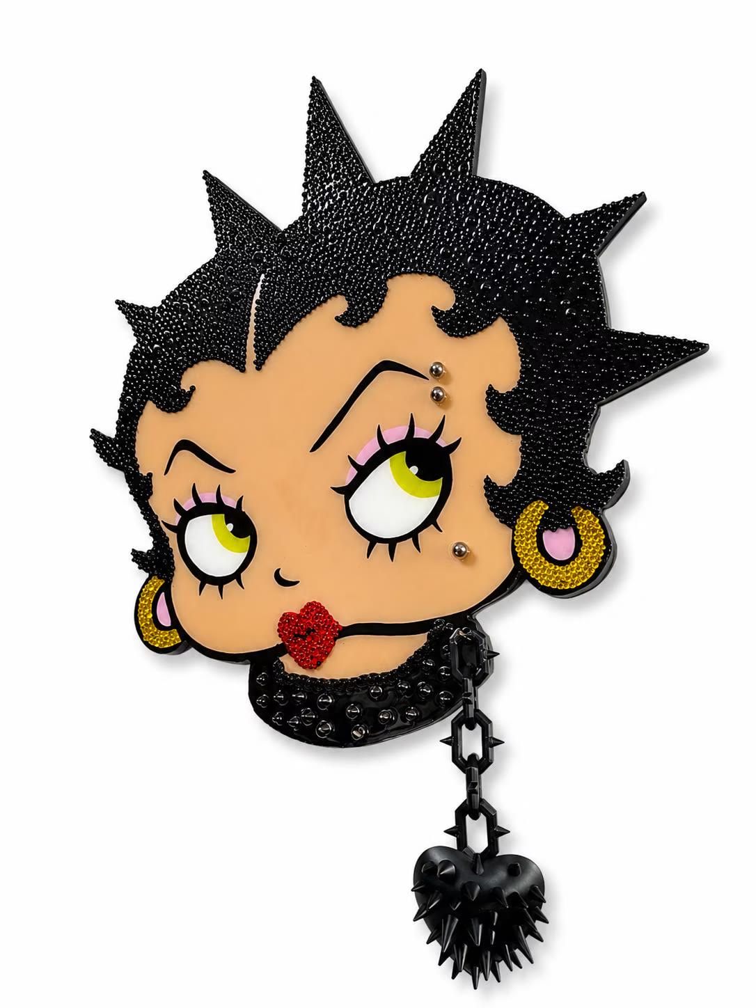 Punk wall art — a black rhinestoned figure with a spiked heart charm, on a white wall.
